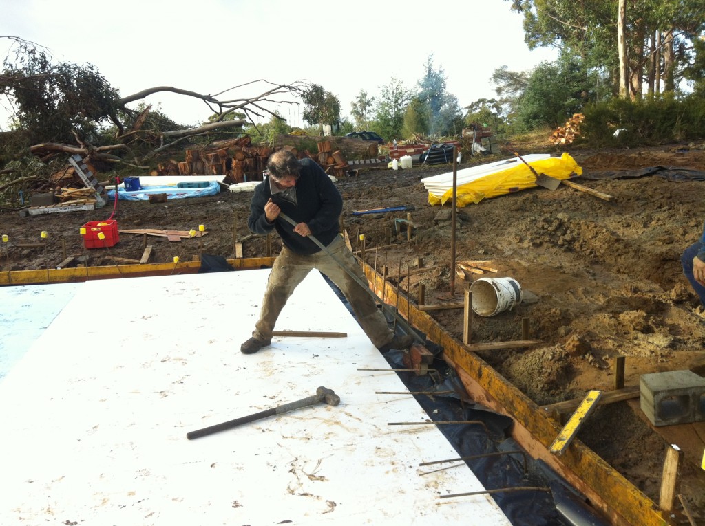 Iron Man! Pete bending the steel reinforcing from the footings back so it can be tied into the slab