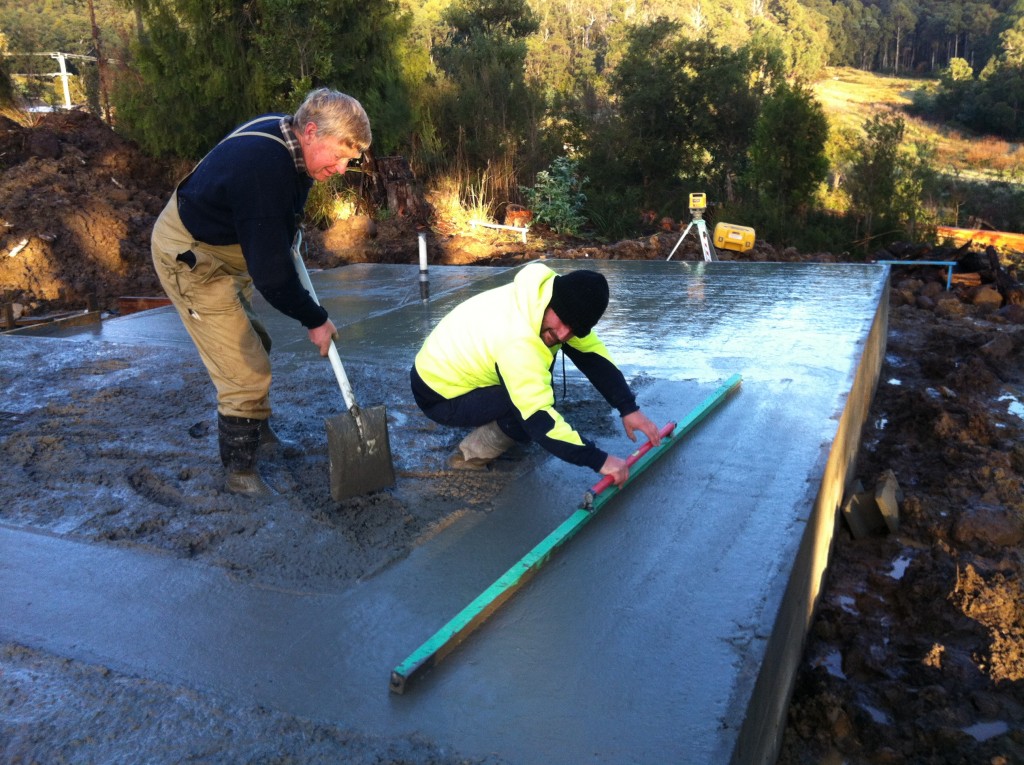 Teamwork: Stuart screeds the concrete while Greg removes the excess