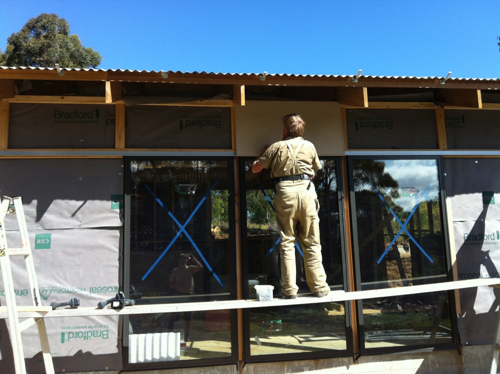 The first piece of cement sheet cladding being put up