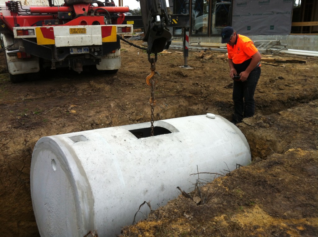 Second time lucky: lowering the septic tank into the hole for the second time