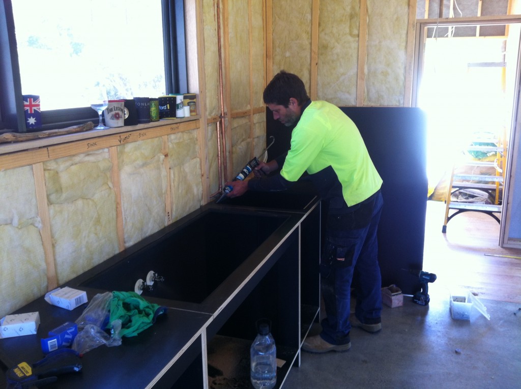 Gunning it: Mark caulking the joins in the bench tops