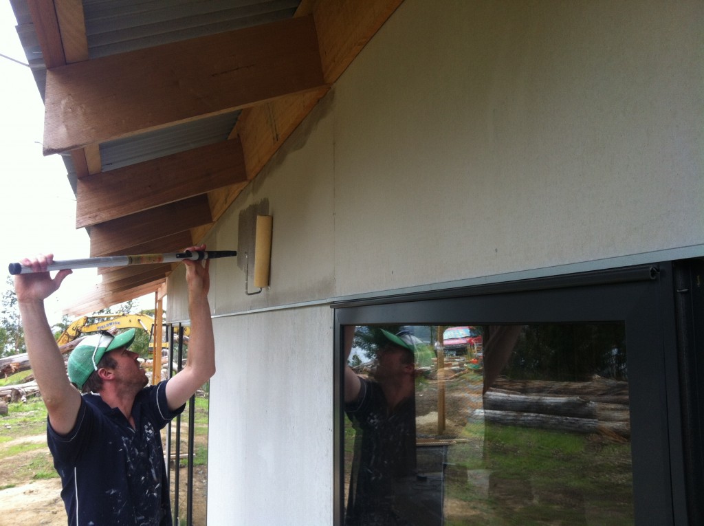 Overhead - Gordon rolling on the clear sealer to the cement sheet cladding