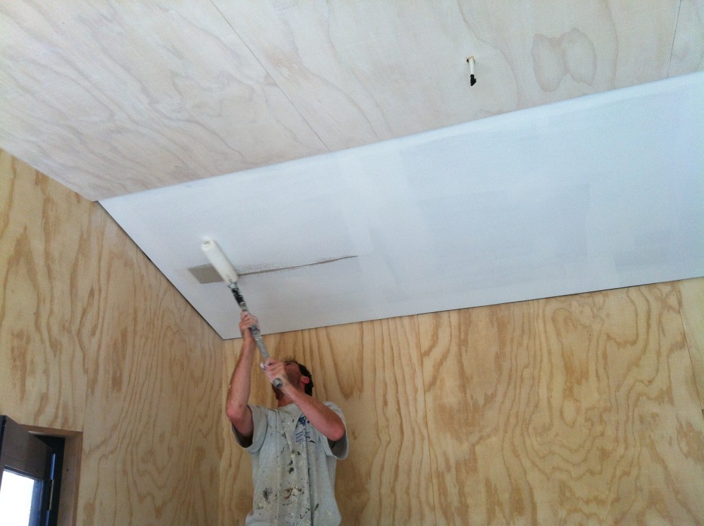 First coat: Gordon rolling the first coat of paint on the plasterboard