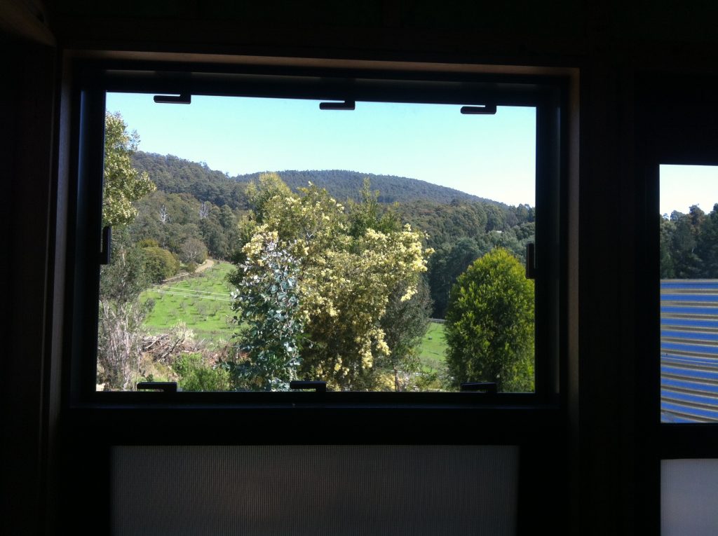 Room with a view: the view from the bathroom for the past six months, framed with spacers holding in the temporary glazing