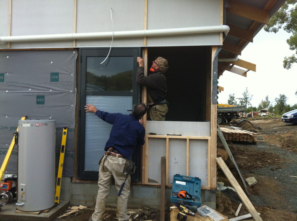 Door to nowhere: Greg and Pete installing the bathroom door, before the deck was built