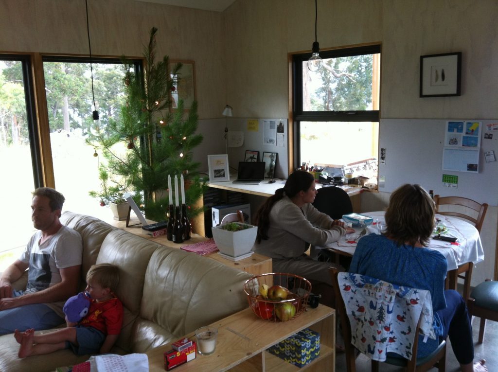 Family unity: boys watching cricket on TV; girls talking at the dining table