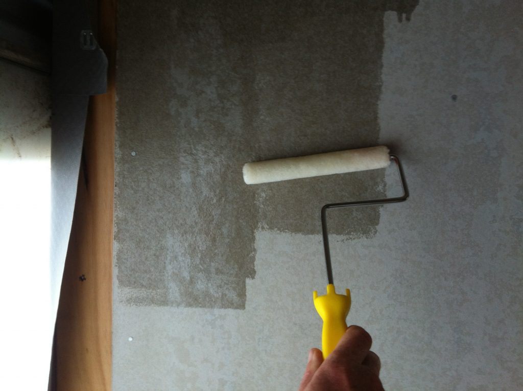 Roller derby: rolling the polyurethane onto the bathroom cement sheet wall